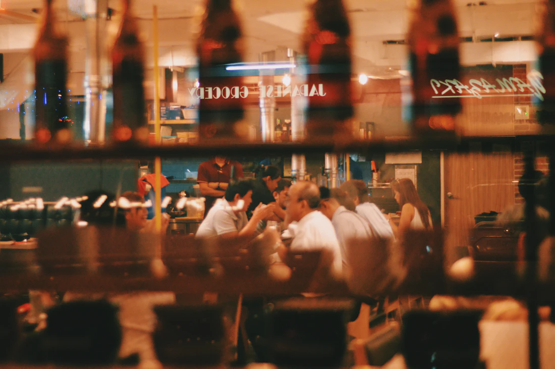 Salão de restaurante com mesas ocupadas e luz quente