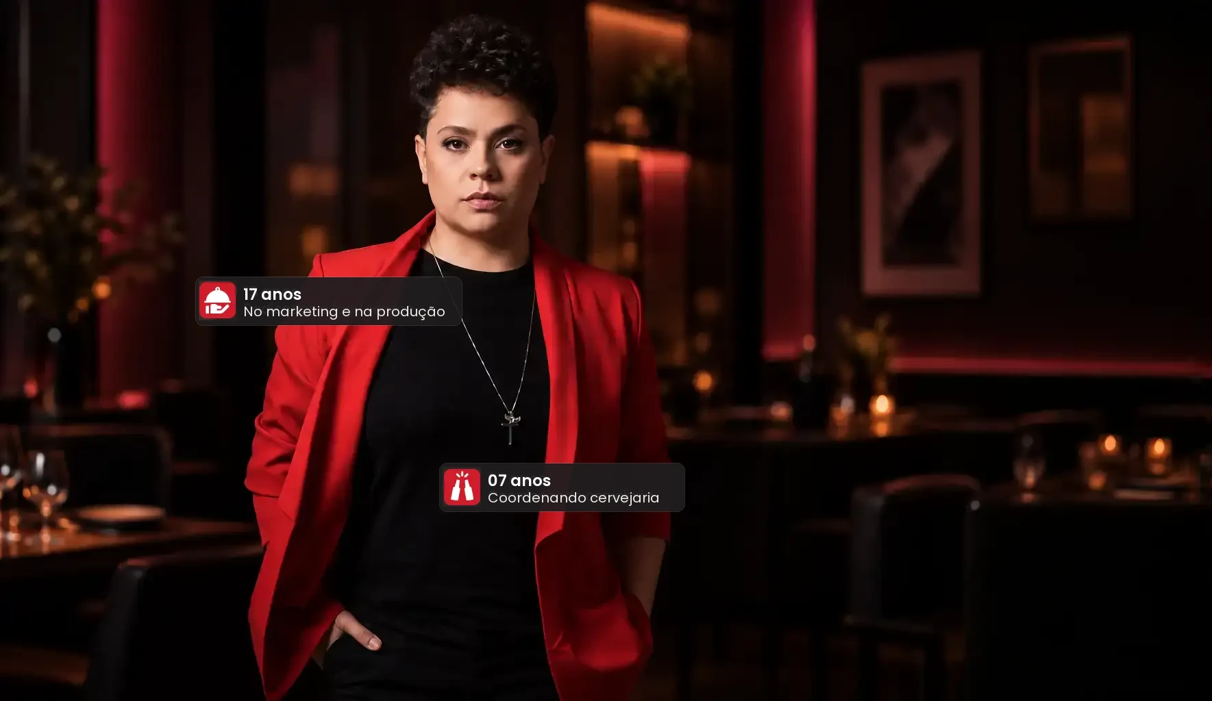 Luciana Leitte de blazer vermelho num restaurante à meia-luz, com os selos de 17 anos no marketing e na produção e 7 anos coordenando cervejaria